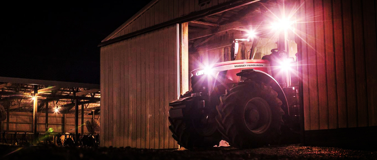 Univeral tractor lights on Massey Ferguson tractor Massey Ferguson tractor leaving tractor shed with Universal high power LED lights shining brightly